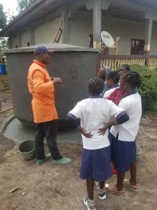 Metselaar vertelt over de Calabash aan groepje schoolmeisjes.